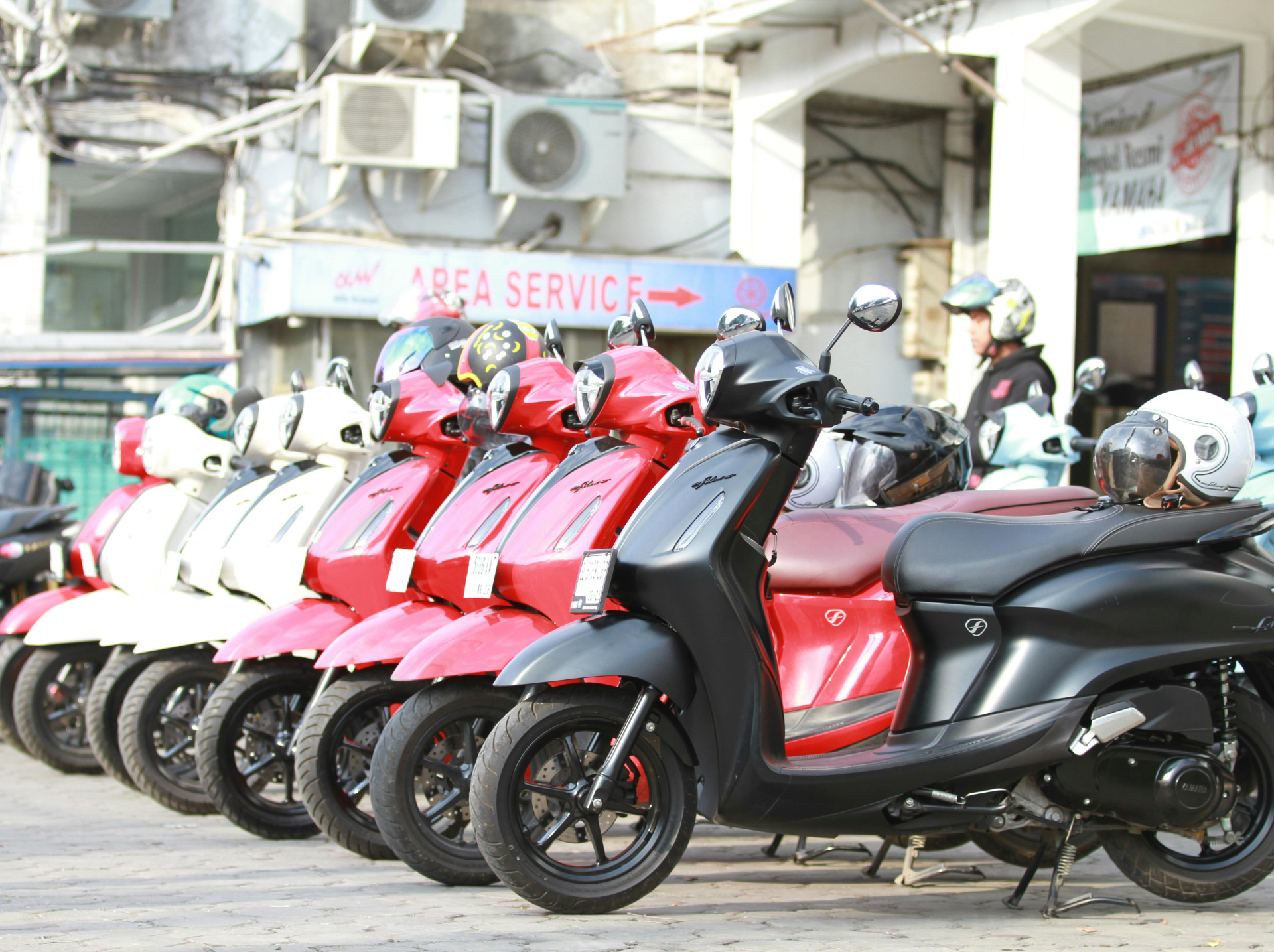 A row of EV scooters neatly parked along a city street