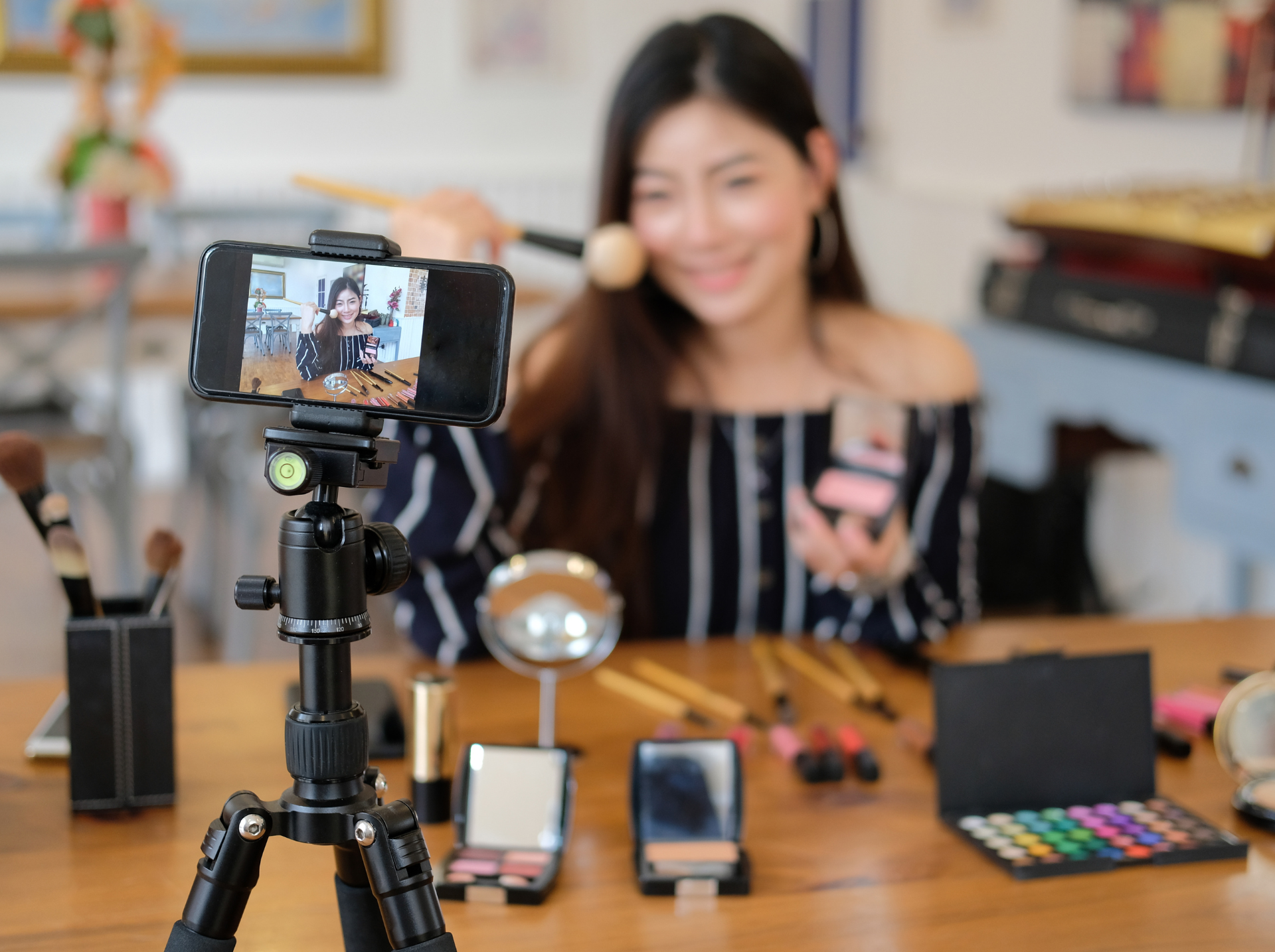 A woman smiling as she takes a selfie with her smartphone, capturing a moment of joy and self-expression.