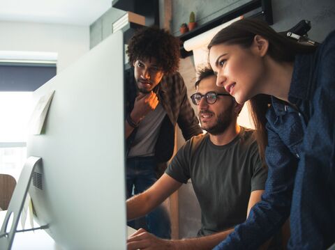 Three people were looking at a monitor