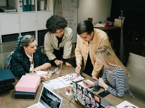 Four people discussing the user journey on a paper choosing the colours