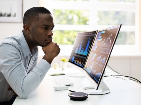 A man watching closesly at the dashboard of analytics to analyse the metrics for the current project