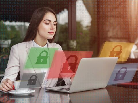 A woman sitting in front of a laptop, with visual representations of locks displayed outside of the screen