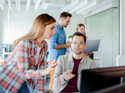 four people in the picture discussing in pairs in a technical setting