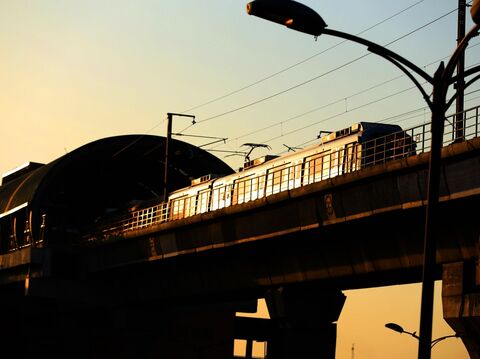 A metro passing a tunnel at sunset