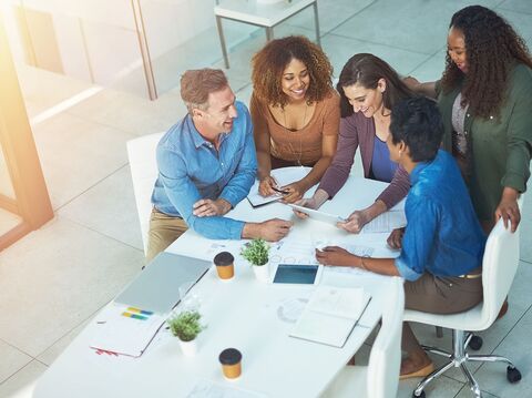 A diverse group of coworkers collaborating over documents at a meeting table