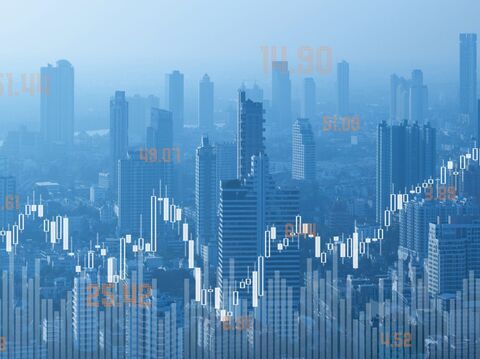 A city skyline with a line graph in the background. The line graph shows increases and decreases in value over time