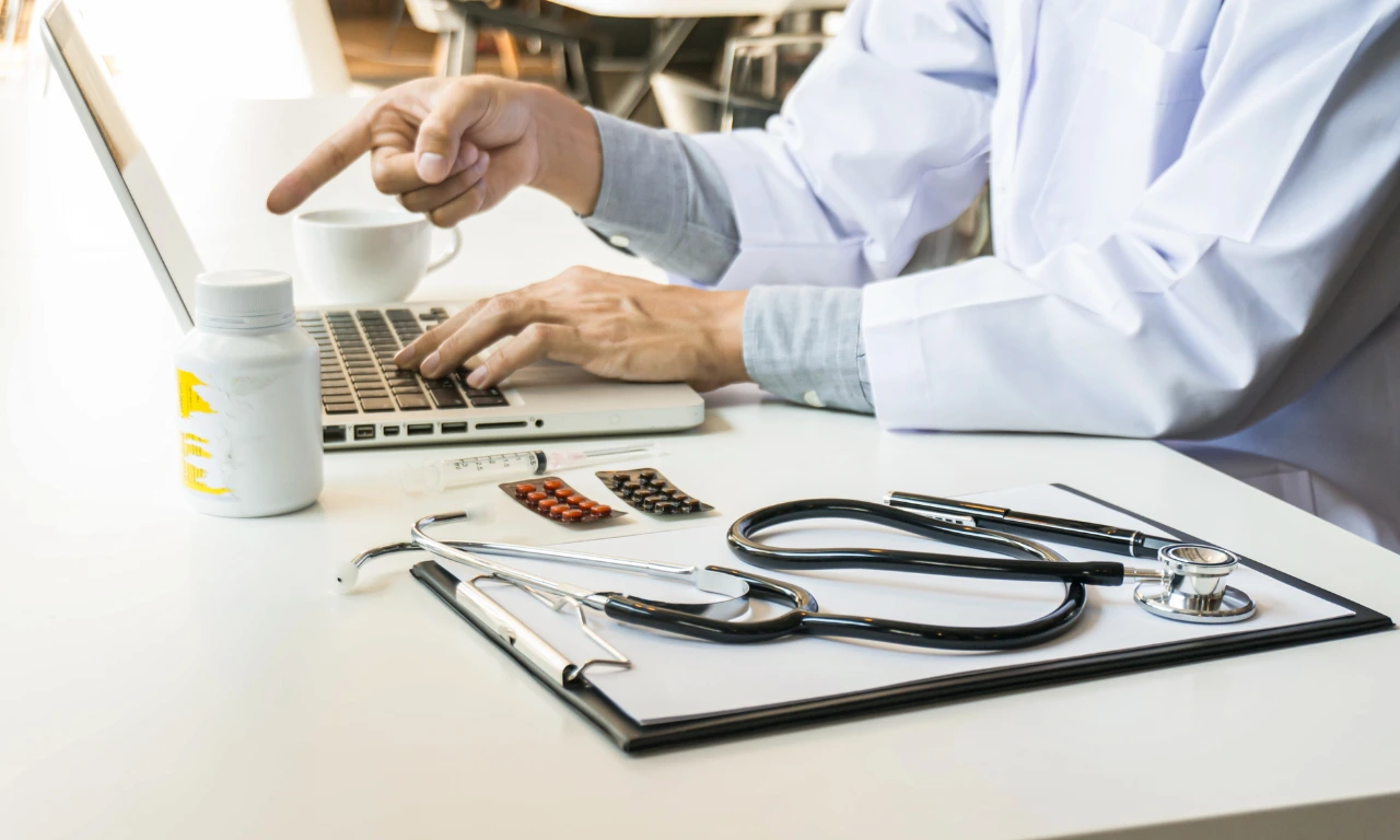 Doctor analysing data on a laptop with medical tools nearby, representing lessons from failed MedTech startups and digital healthcare innovation in India.