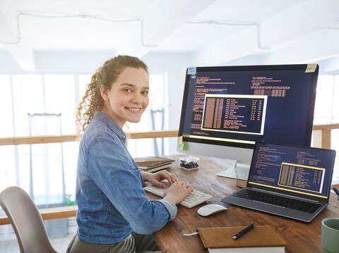 A Women sitting on her work station coding in python