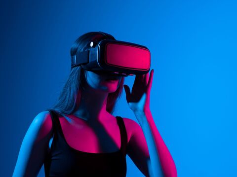 A woman wearing virtual reality glasses, striking a pose while immersed in virtual reality