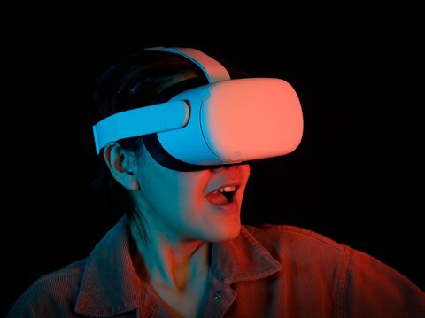 A woman wearing a virtual reality (VR) headset, actively engaged with a virtual environment