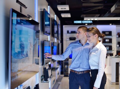 oung couple selecting a flat-screen television in a modern electronics store