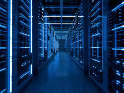 Long corridor of a modern data center illuminated in blue, showcasing rows of server racks on both sides