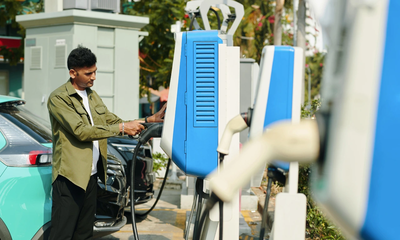 Man charging Electric Vehicle at Charging Station