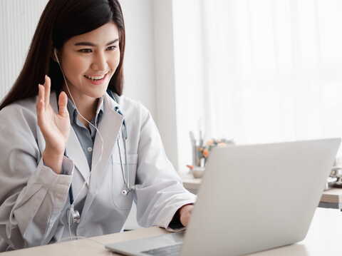 A doctor connected through her laptop providing online consulting to her patients