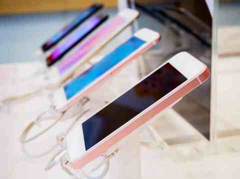 A row of smartphones on display in a store