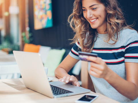 Cheerful curly-haired woman working on her laptop in a stylish office space