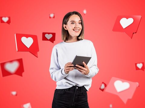 A woman is standing and holding a tab, and a lot of social media likes were illustrated around her 