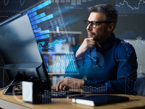 A man is sitting in front of a desktop, on a thinking position