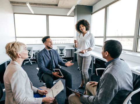 Diverse business team in a meeting, woman presenting to colleagues