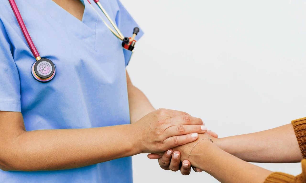 Healthcare professional holding a patient’s hand, symbolising trust, continuity of care, and patient-centric digital health services.