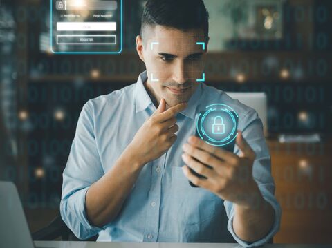 A man holding a smartphone with a digital lock icon overlay and facial recognition graphics