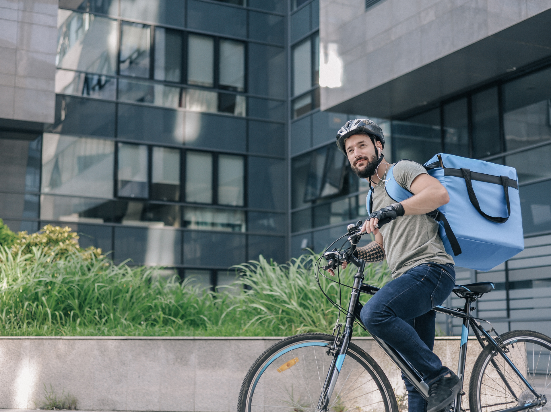 A cheerful delivery worker in a red uniform completes a delivery in an urban setting, illustrating the rapid, customer-centric service of quick commerce that is reshaping the traditional retail landscape.